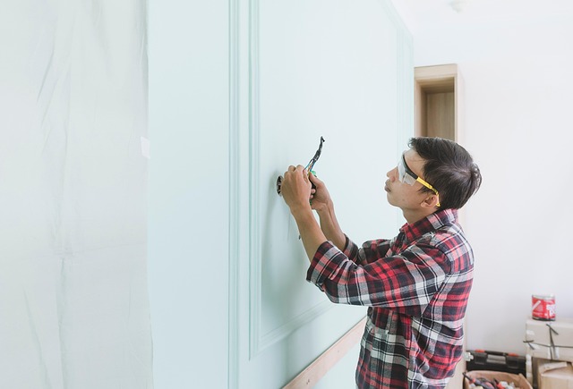 Maintenance man inspecting and working on electrical wiring with safety glasses